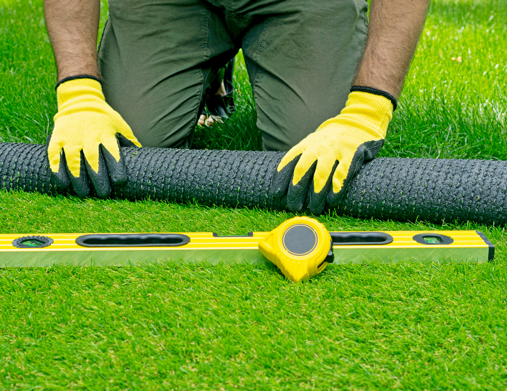 Landscaping,Of,The,Yard,With,Artificial,Turf.,Gardener,Hands,Hold